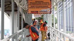 Pekerja mengecat jembatan penyeberangan orang di kawasan Senayan, Jakarta, Jumat (6/7). Pengecatan tersebut merupakan bagian dari proyek revitalisasi JPO guna meningkatnya kenyamanan pejalan kaki. (Liputan6.com/Immanuel Antonius)