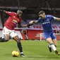 Bek Manchester United (MU), Aaron Wan-Bissaka bersaing dengan bek Everton, Lucas Digne pada laga pekan ke-23 Liga Inggris 2020/2021 di Old Trafford, Minggu dinihari WIB (7/2/2021). MU mampu bermain imbang 3-3 saat menjamu Everton. (Alex Pantling/Pool via AP)