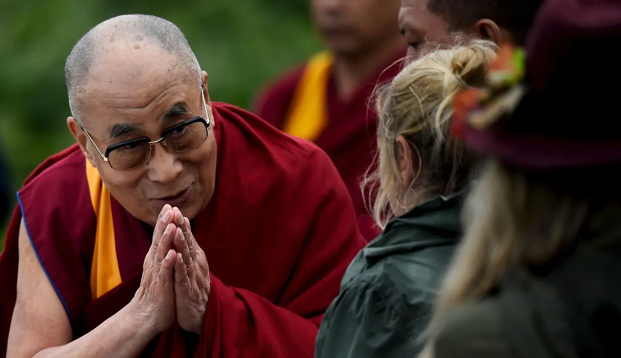 Dalai Lama menyapa salah satu penonton saat tiba di acara Glastonbury Festival, Inggirs, (28/6/2015). Dalai Lama akan berulang tahun yang ke-80 pada 6 Juli 2015 nanti. Namun ia merayakannya lebih awal di Glastonbury Festival. (REUTERS/Dylan Martinez)