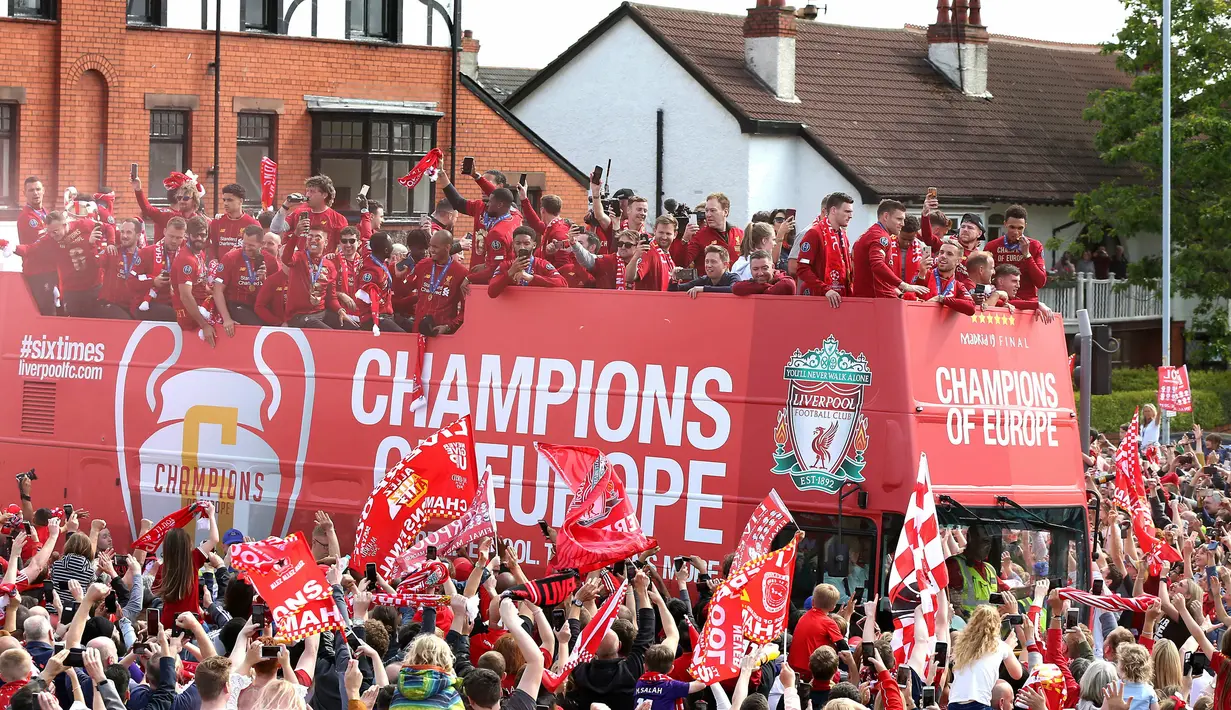 Pemain Liverpool menyapa para suporter saat parade juara Liga Champions di Liverpool, Inggris (2/6/2019). Ribuan suporter tumpah ruah di jalanan merayakan kemenangan tim kesayangannya meraih piala Liga Champions usai mengalahkan Tottenham di final dengan skor 2-0. (Barrington Coombs/PA via AP)