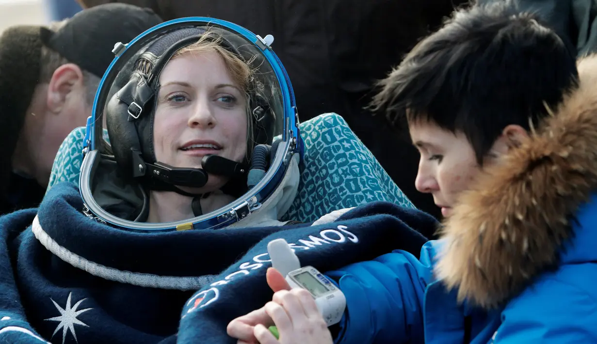 Astronot Kate Rubins dari AS di periksa kesehatannya oleh regu penyelamat badan antariksa Rusia setelah berhasil melakukan pendaratan di  Dzhezkazgan, Kazakhstan (30/10). (Reuters/Dmitri Lovetsky)