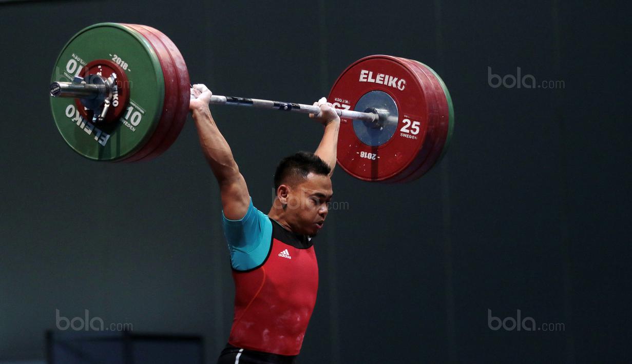 Aksi Eko Yuli Irawan menahan beban angkatan 135 kg snacth saat turun pada kelas 62 kg di Hall A Arena PRJ, Jakarta, Rabu (11/2/2018). Eko berhasil menyabet medali emas. (Bola.com/Nicklas Hanoatubun)