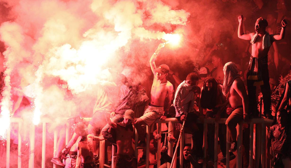 Suporter PSS Sleman menyalakan flare saat melawan Semen Padang pada laga Liga 2 di Stadion Pakansari, Jawa Barat, Selasa (4/12). PSS menang 2-0 atas Semen Padang. (Bola.com/M. Iqbal Ichsan)