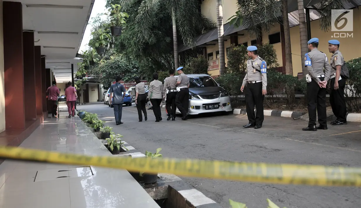 Petugas berjaga dekat garis polisi yang terpasang menuju gedung forensik RS Polri, Kramatjati, Rabu (9/5). Penjagaan super ketat diberlakukan di mana jenazah korban kerusuhan rutan Mako Brimob Kelapa Dua dibawa ke RS Polri. (Merdeka.com/Iqbal S. Nugroho)