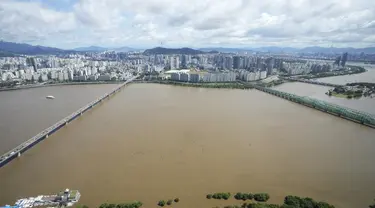 Sungai Han, yang meluap karena banjir, mengalir di bawah jembatan di Seoul, Korea Selatan (6/9/2022). Topan paling kuat yang melanda Korea Selatan selama bertahun-tahun menerjang wilayah selatannya Selasa, membuang satu meter (3 kaki) air hujan, menghancurkan jalan dan meruntuhkan kabel listrik, menyebabkan 66.000 rumah tanpa listrik saat ribuan orang mengungsi ke tempat yang lebih aman. (AP Photo/Ahn Young-joon)