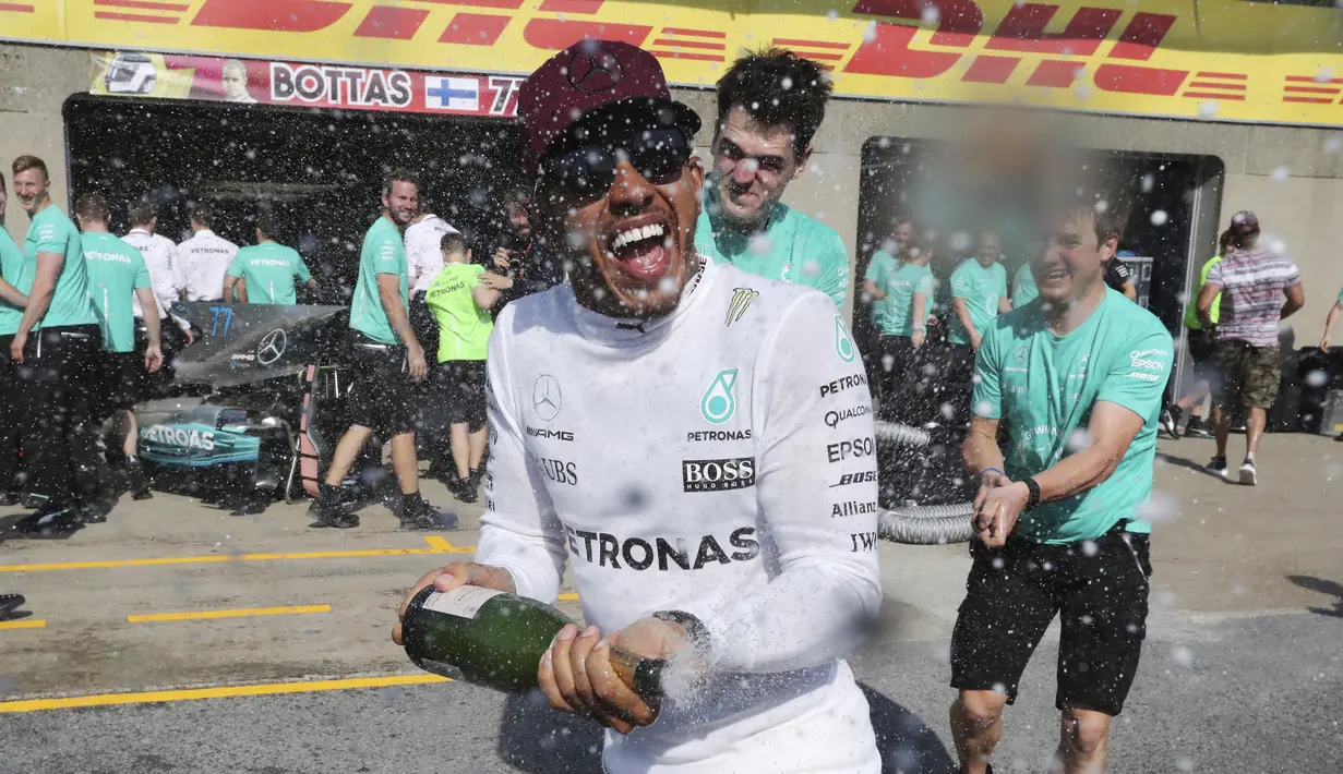 Pebalap Mercedes, Lewis Hamilton merayakan kemenangan usai menjuarai ajang Formula One Canadian Grand Prix di Montreal, Canada, (11/6/2017).  (Tom Boland/The Canadian Press via AP)