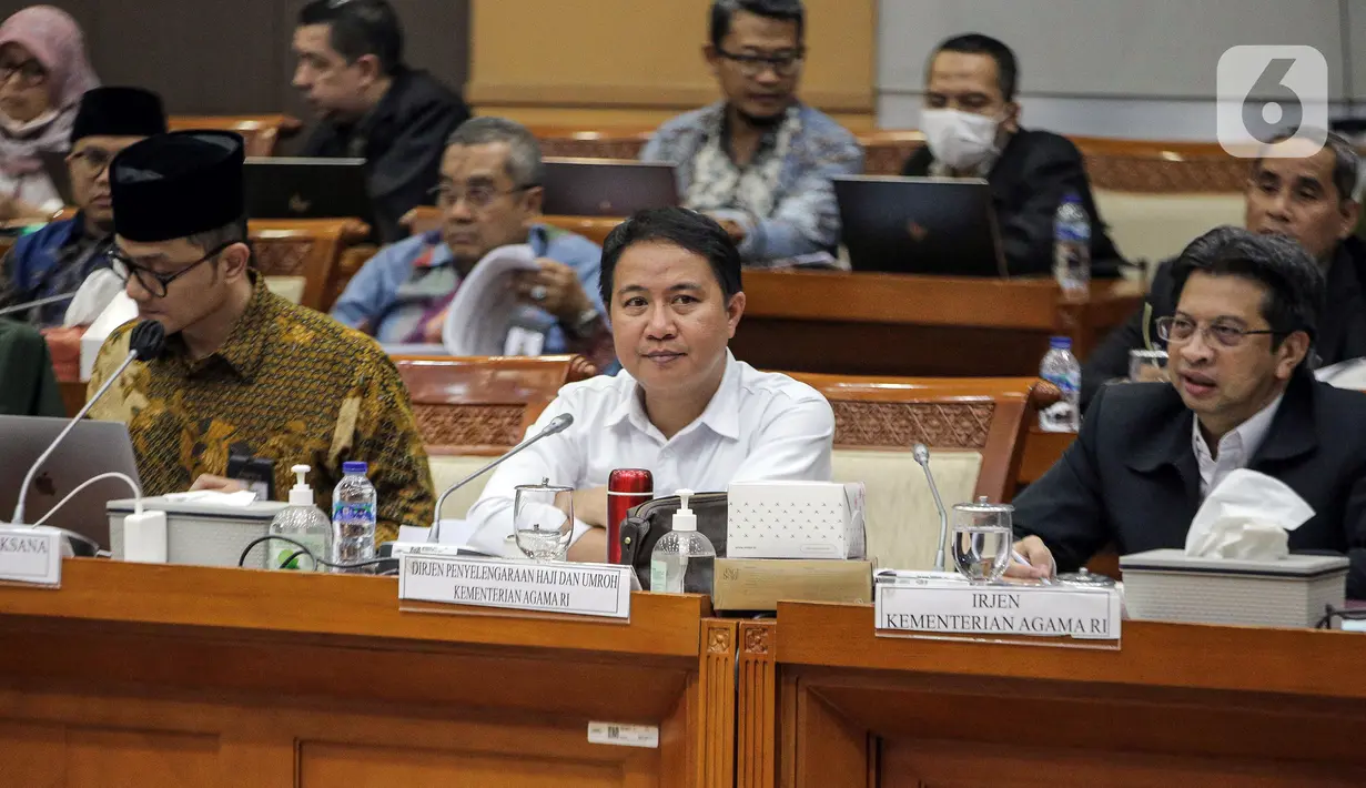 Dirjen Penyelenggaraan Haji dan Umrah (PHU) Hilman Latief (tengah) dan Kepala Badan Pengelola Keuangan Haji (BPKH) Fadlul Imansyah (kiri) menyampaikan paparan saat rapat dengar pendapat bersama Komisi VIII DPR di Kompleks Parlemen, Senayan, Jakarta, Selasa (14/2/2023). Pengumuman terkait besaran biaya haji terpaksa ditunda hingga besok lantaran pemerintah bersama Panja Komisi VIII DPR masih belum menemui kesepakatan. (Liputan6.com/Faizal Fanani)