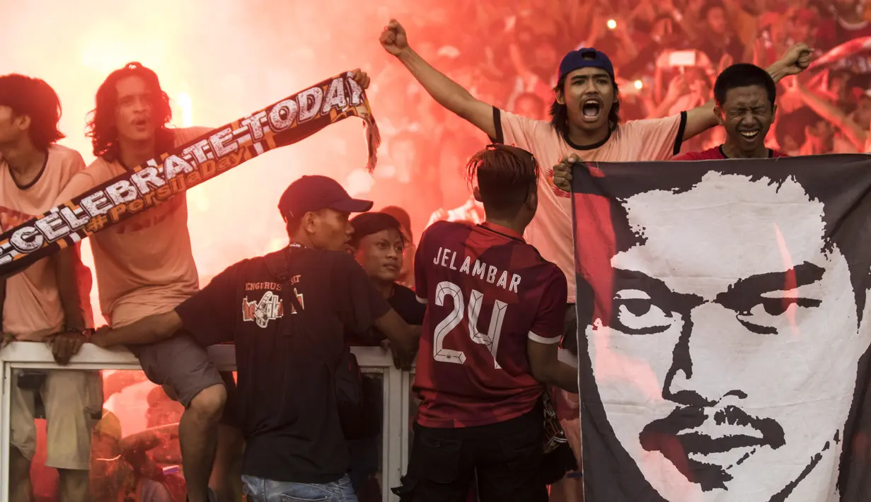 Suporter Persija Jakarta, The Jakmania, merayakan gelar juara usai mengalahkan Mitra Kukar pada laga Liga 1 di SUGBK, Jakarta, Minggu (9/12). Persija menang 2-1 atas Mitra. (Bola.com/Vitalis Yogi Trisna)