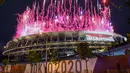 Kembang api menerangi langit di atas Olympic Stadium, saat upacara pembukaan Olimpiade Tokyo 2020, di Tokyo, Jumat (23/7/2021). Upacara pembukaan Olimpiade Tokyo yang berlangsung dalam era pandemi digelar tanpa penonton. (Photo by Kazuhiro NOGI / AFP)