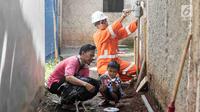Petugas PT Perusahaan Gas Negara (PGN) memeriksa meteran jaringan gas bumi di perumahan warga di kawasan Cibinong, Bogor, Jawa Barat, Jumat (14/12). Pemerintah melalui PGN memberi tambahan 5.120 jargas pada tahun 2018. (Liputan6.com/Immanuel Antonius)
