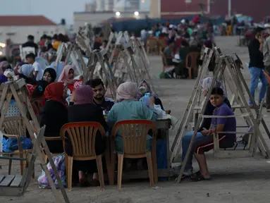Suasana berbuka puasa saat bulan suci Ramadan di pantai Kota Gaza, Palestina, Kamis (21/5/2020). Di tengah pandemi COVID-19, berbuka puasa bersama di pantai Kota Gaza tetap ramai. (AP Photo/Adel Hana)