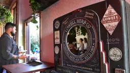 Pelayan membawa makanan dari ruangan menuju keluar di Lowell Cafe di Hollywood Barat, California  (30/9/2019). Kafe ini menawarkan pengunjung berbagai produk gulma dan berharap dapat menyaingi toko kopi terkenal di Amsterdam. (AFP Photo/Frederic J. Brown)