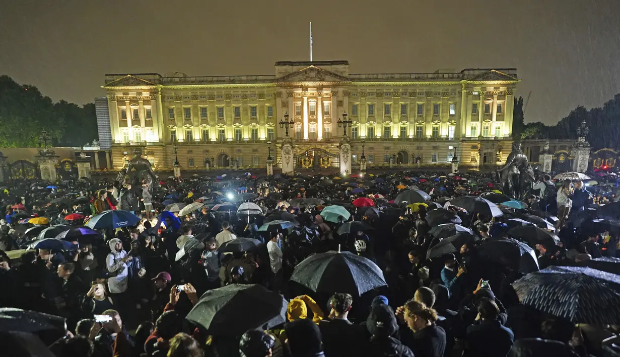 Orang-orang berkumpul di luar Istana Buckingham menyusul pengumuman kematian Ratu Elizabeth II, di London, Kamis, 8 September 2022. Dengan wajah berduka, suara nyanyian lagu "God Save the Queen" pecah di antara kerumunan yang berkumpul. (Victoria Jones/PA via AP)