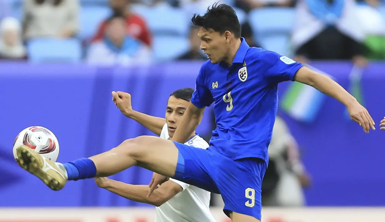 Striker Timnas Thailand, Supachai Chaided (depan) mengontrol bola di depan bek Uzbekistan, Umarbek Eshmurodov pada laga babak 16 besar Piala Asia 2023 di Al Janoub Stadium, Al Wakrah, Qatar, Selasa (30/1/2024). (AP Photo/Hussein Sayed)