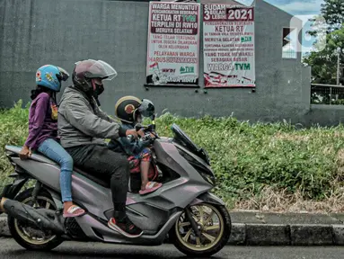 Warga melintasi spanduk meminta pelantikan RT di Meruya di Perumahan Taman Villa Meruya (TMV) Meruya Selatan, Kembangan, Jakarta Barat, Sabtu (26/2/2022). (Liputan6.com/Faizal Fanani)