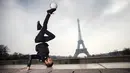 Moss dari S3 Society dance group beraksi bersama bola di the Place du Trocadero, dengan  latar menara Effeil, Paris, Jumat (18/3/2016).  S3 Society akan tampil pada Euro 2016 Pracis tanggal 10 Juni-10 Juli 2016. (AFP/Lionel Bonaventure)