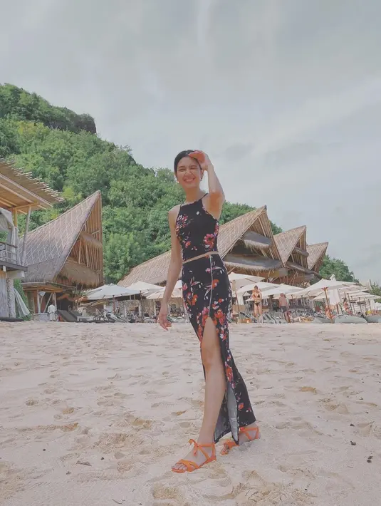 Pakaian dua potong bergaya midriff juga jadi favorit Mikha. Kali ini dengan rok panjang berbelah dan crop top hitam bermotif floral. [@miktambayong]