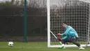 Kiper Chelsea Thibaut Courtois berusaha menangkap bola saat latihan di fasilitas latihan Chelsea Cobham di Stoke D'Abernon, sebelah barat daya London (19/2). Chelsea akan bertanding melawan Barcelona di Stamford Bridge. (AFP Photo/Adrian Dennis)