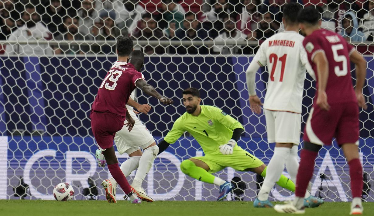 Pemain Qatar, Almoez Ali (kiri) mencetak gol kemenangan timnya ke gawang iran pada laga semifinal Piala Asia 2023 di Al Thumama Stadium, Doha, Qatar, Rabu (07/02/2024). (AP Photo/Aijaz Rahi)