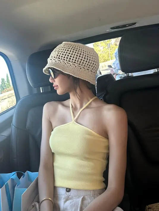 Rapper itu kemudian melengkapi penampilannya dengan tas bahu dan topi ember yang terbuat dari bahan raffia. [Instagram/lalalalisa_m]