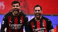 Pemain AC Milan Theo Hernandez merayakan golnya ke gawang Lazio bersama Hakan Calhanoglu pada pertandingan Serie A di San Siro, Kamis (24/12/2020) dini hari WIB. (AFP/Marco Bartorello)