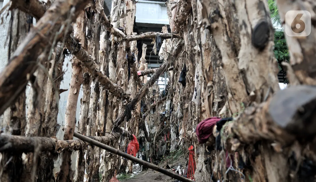 Kondisi tanggul kayu yang rusak dan penuh sampah di bantaran Kali Ciliwung, Rawajati, Pancoran, Jakarta, Minggu (5/1/2020). Tanggul dari kayu dolken dan karung pasir yang baru dibangun pada akhir Desember 2019 itu rusak hingga dipenuhi sampah akibat terjangan arus banjir. (merdeka.com/Iqbal Nugroho)