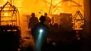 Petugas pemadam kebakaran Layanan Darurat Negara Ukraina berusaha memadamkan api setelah penembakan Rusia menghantam sebuah pusat perbelanjaan di Kherson, Ukraina, 3 Februari 2023. Asap membumbung tinggi dari pusat perbelanjaan yang terbakar setelah serangan Rusia ke pusat perbelanjaan tersebut. (AP Photo/LIBKOS)