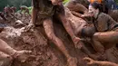 Peserta membantu rekannya untuk melewati kolam lumpur saat mengikuti Mud Day di Tel Aviv, Israel (24/3). Mud day atau Hari Lumpur ini pertama kali diperkenalkan di Paris pada 2013. (AP Photo/Oded Balilty)