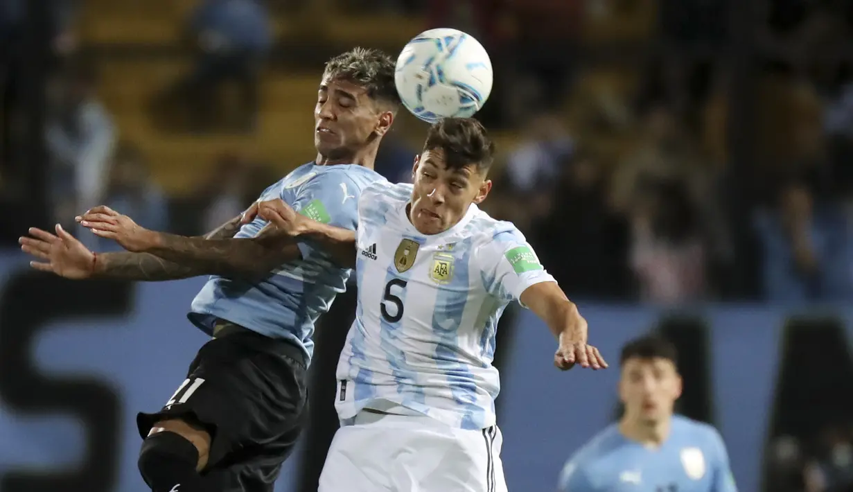 Pemain Argentina, Nahuel Molina berebut bola udara dengan pemain Uruguay, Martin Caceres selama pertandingan penyisihan Piala Dunia di Estadio Campeon del Siglo, Montevideo, Uruguay, Sabtu (13/11/2021). Argentin kini duduk di posisi kedua dengan 28 poin dari 12 laga. (Ernesto Ryan/Pool Via AP)