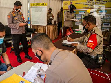 Polisi mendata warga saat rapid test gratis di Pos Pengamanan Natal 2020 dan Tahun Baru 2021 Polsek Kebayoran Lama, Jakarta, Selasa (29/12/2020). Rapid test itu dilakukan untuk membantu mengurai antrean warga saat tes di tempat lainnya. (Liputan6.com/Faizal Fanani)