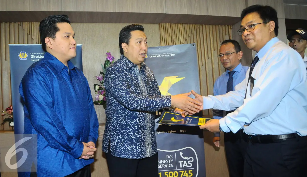 Presiden Direktur PT Adaro Energy Tbk, Garibaldi Thohir (kedua kiri) dan Pengusaha nasional Erick Thohir (kiri) menyerahkan laporan data aset kepada Kepala Kanwil DJP Wajib Pajak Besar, Jakarta, Rabu, (14/9). (Liputan6.com/Angga Yuniar)