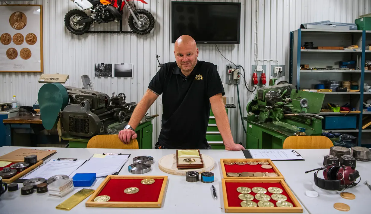 Perajin Niklas Qvarnstrom berpose saat pembuatan medali hadiah Nobel di Eskilstuna, Swedia, 29 Oktober 2019. Hadiah Nobel digelar untuk memperingati kematian Alfred Nobel, penemu dinamit asal Swedia dan bahan peledak tinggi lainnya. (Jonathan NACKSTRAND/AFP)