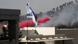 Sebuah pesawat pemadam kebakaran bekerja memadamkan api yang berkobar di kawasan hutan dekat Kibbutz Neve Ilan di sebelah barat Yerusalem, Israel, Rabu (9/6/2021). Kebakaran hebat di pinggiran Yerusalem melumpuhkan lalu lintas. (Ahmad GHARABLI/AFP)