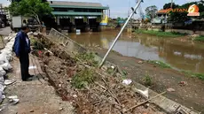 Tampak tiang listrik roboh miring akibat amblasnya tanggul Banjir Kanal Barat (Liputan6.com/Andrian M Tunay)