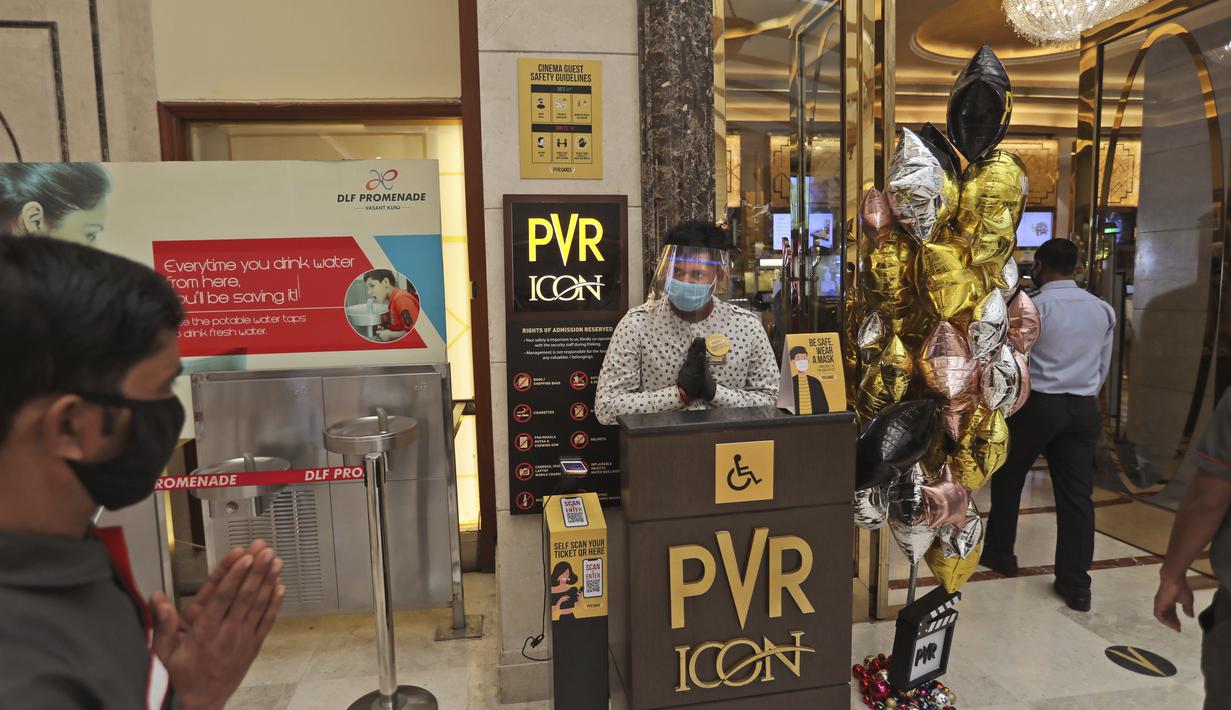 Seorang karyawan menyambut para pejuang COVID-19 dan keluarganya saat bioskop dibuka kembali di bioskop PVR di New Delhi, India (15/101/2020). Salah satu jaringan bioskop terbesar di India, PVR Cinemas, menyatakan telah mulai beroperasi mulai hari ini, Kamis (15/10). (AP Photo/Manish Swarup)