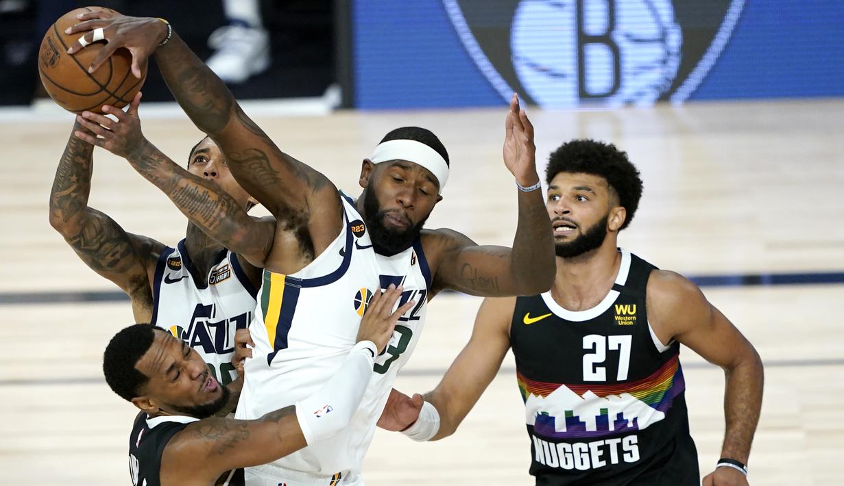 Pemain Utah Jazz, Jordan Clarkson, berebut bola dengan pemain Denver Nuggets, Monte Morris, pada ronde pertama playoff NBA musim 2020 di The Field House, Florida, Selasa (18/8/2020). Denver Nuggets menang 135-125 atas Utah Jazz. (AFP/Ashley Landis/Pool/Getty Images)
