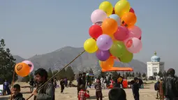 Seorang pria Afghanistan menjual balon selama perayaan untuk Nowruz, Tahun Baru Persia, di Kabul, (21/3). Nowruz dirayakan pada hari pertama musim semi di negara-negara termasuk Afghanistan, Tajikistan, dan Iran. (AP Photo/Rahmat Gul)