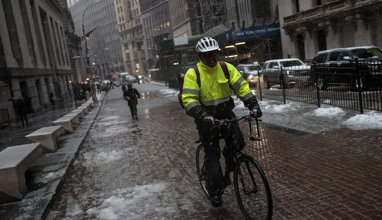 Pengendara sepeda melintasi Financial District saat badai salju di New York City (7/3). Badai salju kedua yang melanda New York dalam waktu seminggu ini diperkirakan akan membawa angin kencang. (Drew Angerer/Getty Images/AFP)