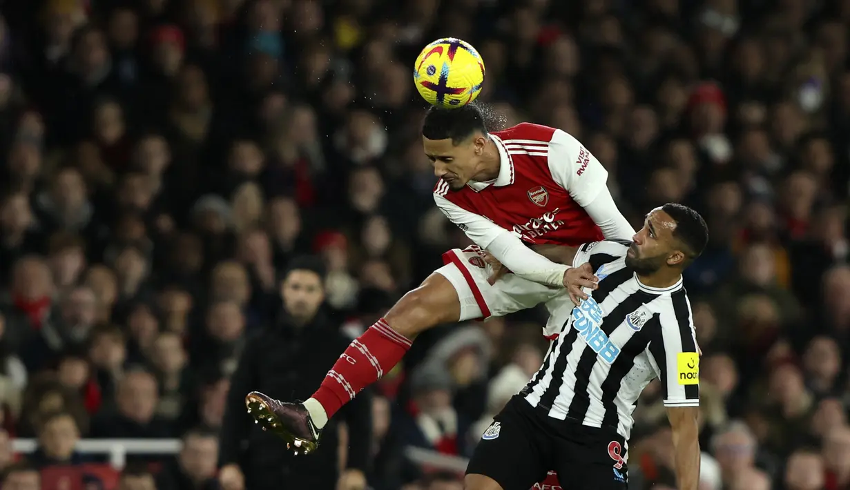 <p>Bek Arsenal, William Saliba berduel memperebutkan bola dengan pemain Newcastle United, Callum Wilson selama pertandingan lanjutan Liga Inggris di stadion Emirates di London, Rabu (4/1/2023). Arsenal bermain imbang atas Newcastle dengan skor 0-0. (AP Photo/Ian Walton)</p>
