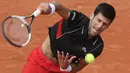 Petenis Serbia, Novak Djokovic mengembalikan bola ke petenis Italia Marco Cecchinato pada perempatfinal Prancis Terbuka 2018 di stadion Roland Garros, Selasa (5/6). Djokovic dikalahkan petenis non-unggulan dalam duel empat set. (AP/Alessandra Tarantino)