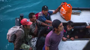 Penduduk Pulau Sebuku menunggu proses evakuasi sebelum menaiki kapal TNI Angkatan Laut dari rumah mereka yang terkena dampak tsunami di perairan Selat Sunda (28/12). (AP Photo/Fauzy Chaniago)