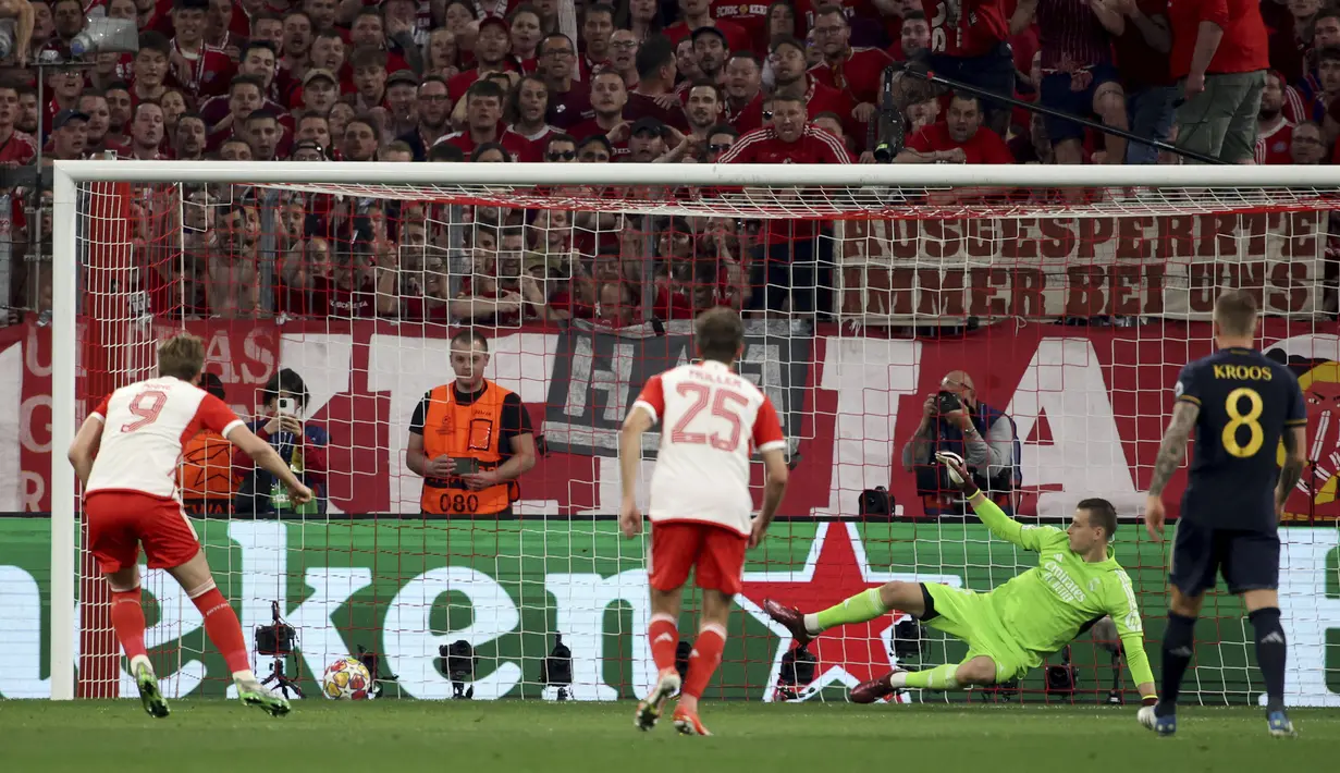 Striker Bayern Munchen, Harry Kane (kiri) mencetak gol kedua timnya ke gawang Real Madrid melalui eksekusi penalti pada laga leg pertama semifinal Liga Champions 2023/2024 di Allianz Arena, Munich, Selasa (30/4/2024). (dpa via AP Photo/Matthias Balk)