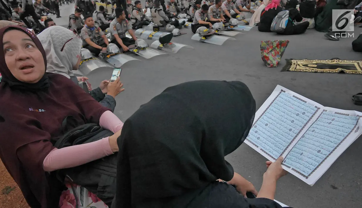Massa Gerakan Nasional Kedaulatan Rakyat membaca al-quran saat unjuk rasa di kawasan Bundaran HI, Jakarta, Selasa (21/5/2019). Dalam aksinya, mereka Bawaslu memeriksa hasil Pemilu 2019 yang dinilai banyak terdaopat kecurangan. (Liputan6.com/Herman Zakharia)