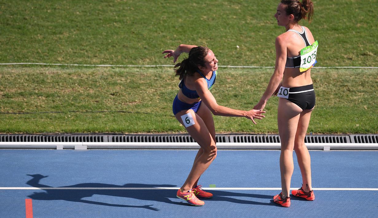 Pelari Nikki Hamblin terlihat membantu pelari AS, Abbey D'Agostino saat mengalami nyeri kaki setelah terjatuh pada lari 5000m putri Olimpiade Rio 2016 di Olympic  Stadium, Rio de Janeiro, (16/8/2016). (AFP/Johannes Eisele)