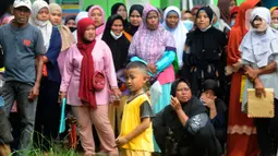 Seorang anak berdiri di antara warga yang antre saat penyaluran bantuan langsung tunai (BLT) Kemensos di Kecamatan Ciseeng, Bogor, Jawa Barat, Senin (28/11/2022). Setiap Keluarga Penerima Manfaat (KPM) mendapat BLT BBM sebesar Rp300ribu, Sembako Rp600 ribu dan bantuan PKH (Program Keluarga Harapan) sebesar Rp600 ribu. (merdeka.com/Arie Basuki)