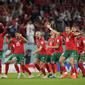 Pemain Maroko merayakan kemenangan timnya setelah mengalahkan Maroko di babak adu penalti saat laga 16 besar Piala Dunia 2022 yang berlangsung di Education City Stadium, Selasa (06/12/2022). (AP/Luca Bruno)