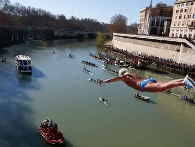 Maurizio Palmulli dari Italia melakukan terjun bebas ke sungai Tiber dari Jembatan Cavour di Roma, Selasa (1/1). Tradisi melompat dari jembatan setinggi 18 meter  dan menyelam ke sungai tersebut sebagai bentuk perayaan tahun baru. (AP/Riccardo De Luca)