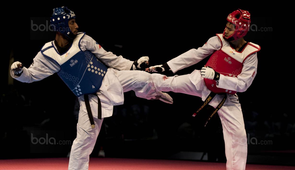 Atlet taekwondo Indonesia, Dinggo Ardian (merah), saat melawan Morrison Samuel, pada final kelas kyorugi -74 kg SEA Games di KLCC, Kuala Lumpur, Minggu (27/8/2017). Kalah di final, Dinggo harus puas meraih perak. (Bola.com/Vitalis Yogi Trisna)