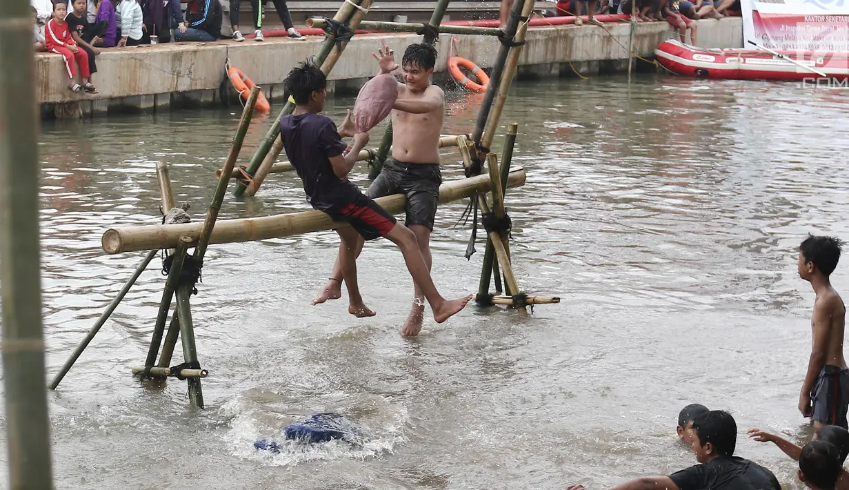 Dua peserta berusaha saling menjatuhkan saat mengikuti lomba gebuk bantal dalam Festival Kalimalang di Cipinang Melayu, Jakarta Timur, Kamis (17/8). Festival Kalimalang ini dalam rangka memeriahkan HUT ke-72 RI. (Liputan6.com/Herman Zakharia)