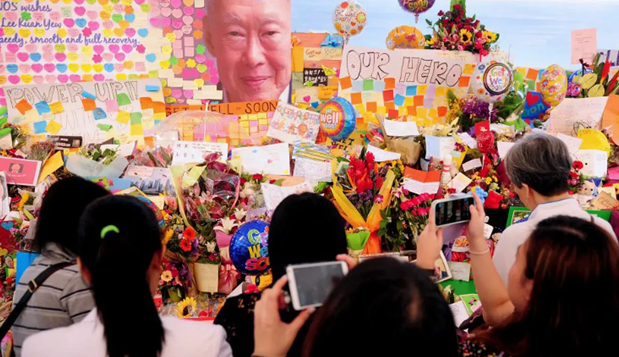 Sejumlah warga berkumpul setelah mendengar kabar meninggalnya mantan PM Singapura, Lee Kuan Yew di Singapore General Hospital, Senin (23/3). Bapak bangsa Singapura ini meninggal dunia dalam usia 91 tahun karena mengidap pneumonia. (AFP PHOTO/Mohd Fyrol)